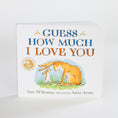 Load image into Gallery viewer, A children's board book titled 'Guess How Much I Love You' by Sam McBratney, illustrated by Anita Jeram. The book features a white cover with blue and orange lettering and an illustration of a large rabbit and a small rabbit in grass.