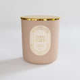 Load image into Gallery viewer, A matte blush pink candle jar with a gold metallic rim and a cream-colored oval label reading 'COCO CLOUD' and 'Ninety-Fifth Avenue.' The candle is photographed on a clean, light gray studio background.