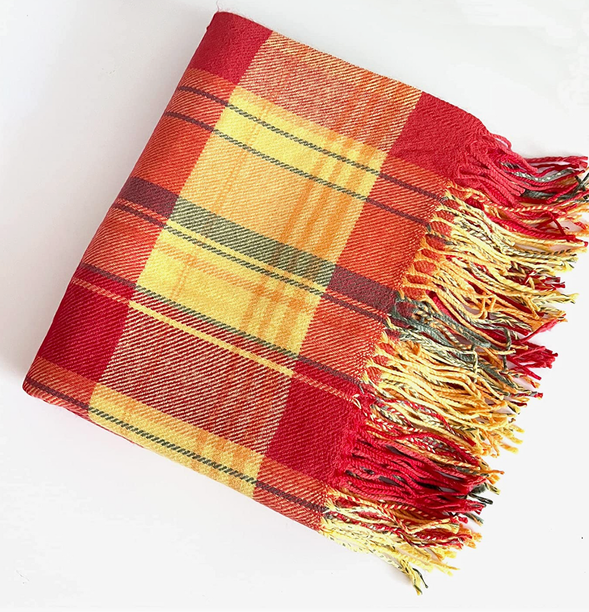 A folded plaid throw blanket with fringed edges, featuring a pattern of red, yellow, orange, and brown stripes, photographed on a clean white background.