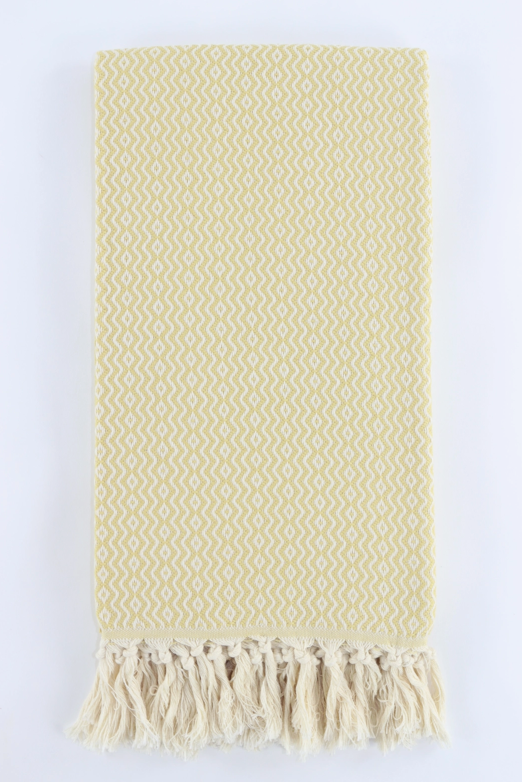 A yellow-colored woven Turkish towel with a geometric diamond pattern and fringed tassels, displayed flat against a white background.