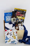 Load image into Gallery viewer, A curated wooden gift box filled with assorted Kansas City sourced packaged goods, including a white chocolate box tied with a navy ribbon, Jack Stack seasoning and bbq sauce, a blue Roasterie coffee bag, a printed Kansas City themed towel, a barbecue sauce bottle from Q39, and a Kansas City Royals blue edition of Topsy's popcorn mix, photographed in a clean studio setup.
