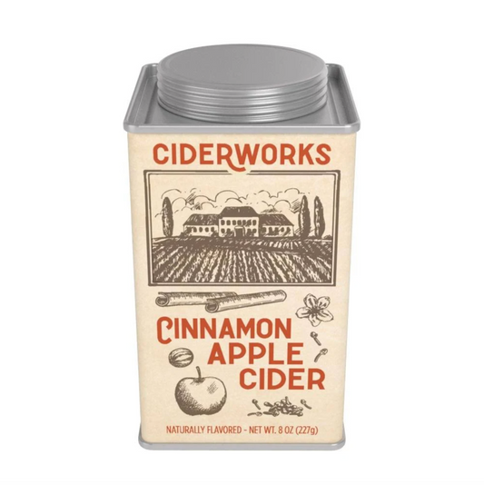 A square metal tin of Ciderworks Cinnamon Apple Cider on a plain white background. The tin has a cream-colored label with brown illustrations of a cider mill, apple, and cider glasses, and red lettering.