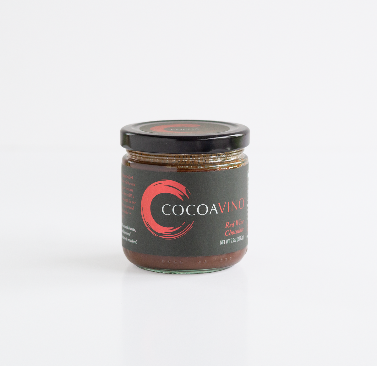 A glass jar of COCOAVINO chocolate spread with a black lid and black label featuring a red circular logo, set against a clean white background.