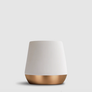 A modern tapered mug in white and a metallic rose gold base, shown against a solid light gray background.