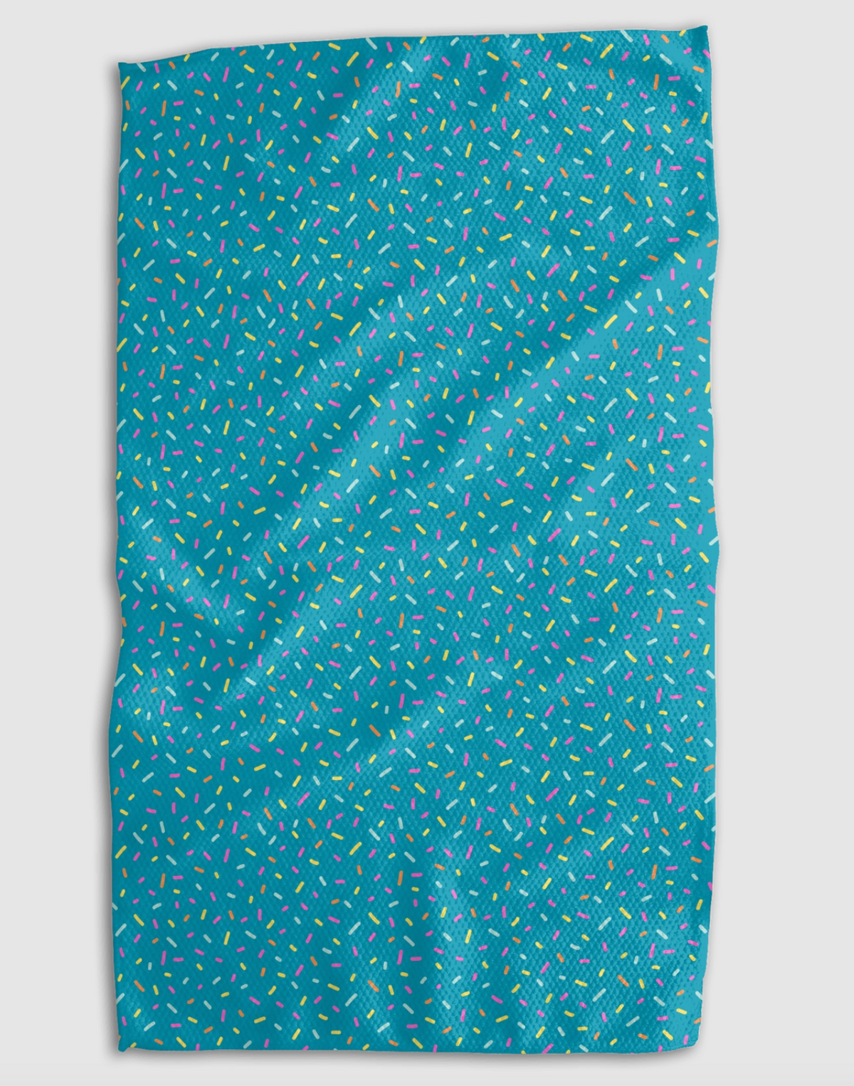 A rectangular blue towel with a dense, all-over pattern of small multicolored confetti sprinkle dots, shown against a neutral light gray background.