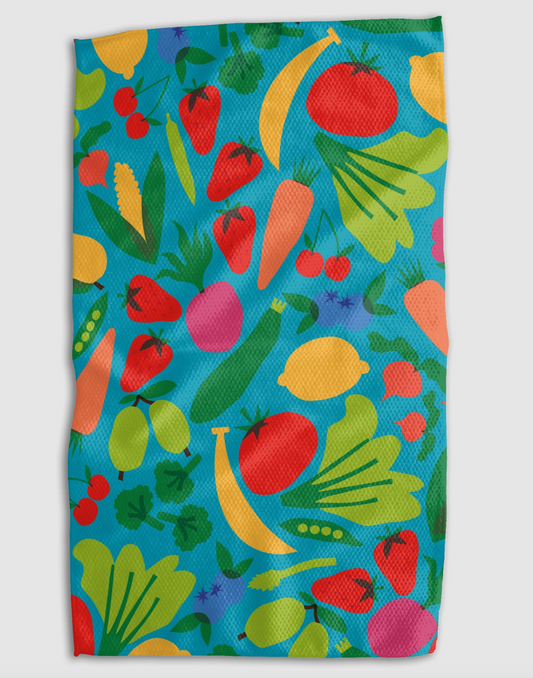 A rectangular kitchen towel or cloth featuring a colorful vegetable print on a turquoise blue background, shown flat against a light gray backdrop.