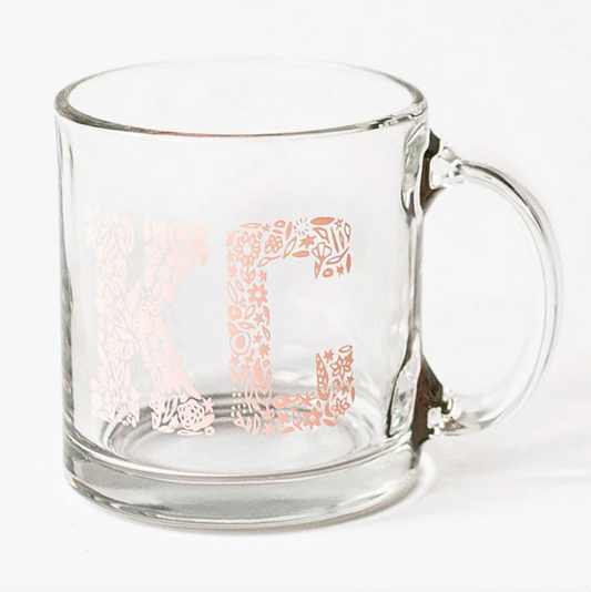 a glass mug with the letters "KC" on it in a pink floral pattern