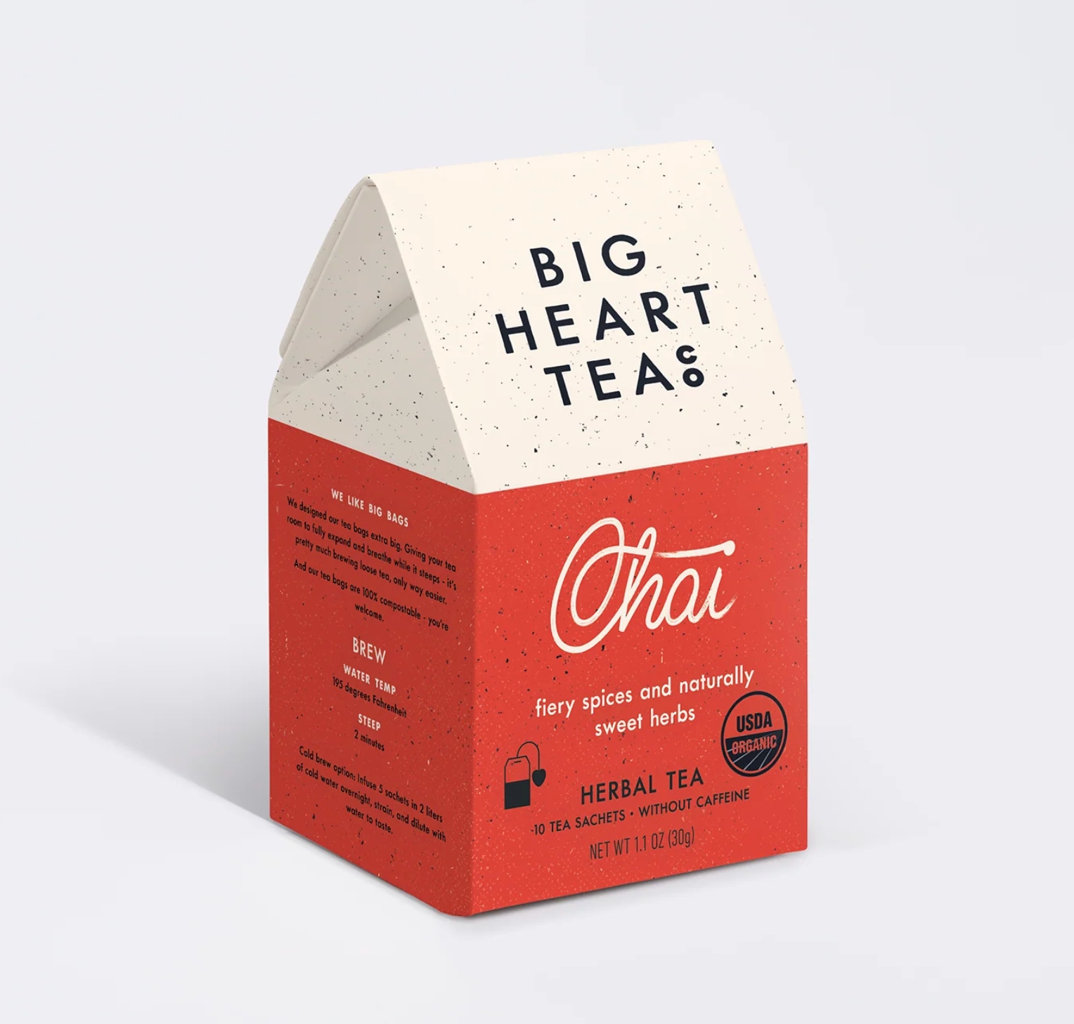 A tea box for Big Heart Tea Chai, featuring a speckled cream top and a terracotta red lower section with white script branding and product details, shown on a light gray background.