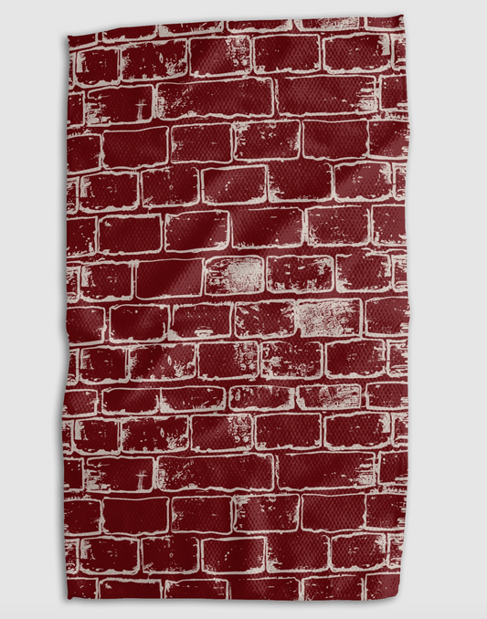 A kitchen towel featuring a distressed red brick wall pattern on a light gray background.