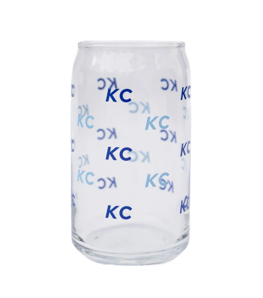 A clear glass can-shaped tumbler with a repeating blue 'KC' logo pattern, shown against a plain white background.
