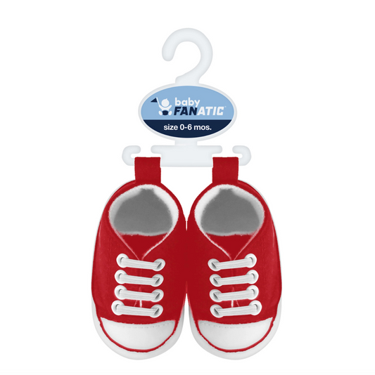 A pair of baby sneaker-shaped shoes in red and white, hanging from a white plastic hanger with a blue 'baby FANATIC' brand tag. The shoes are shown against a plain white background.