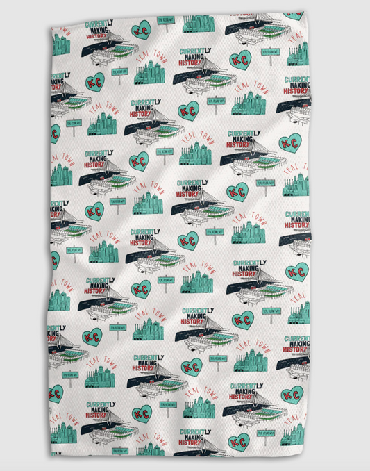 A white kitchen towel featuring a repeating pattern of the Kansas City skyline, the KC Current stadium, and a teal KC heart, including text that reads "TEAL TOWN" and "CURRENTLY MAKING HISTORY"