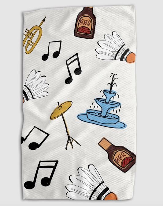 A white kitchen towel featuring a playful pattern of badminton shuttlecocks, black musical notes, a brass trumpet, a blue fountain, and brown bottles labeled 'BBQ'.
