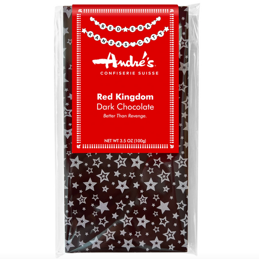 A packaged bar of Andre's Red Kingdom Dark Chocolate in a clear plastic bag with a bright red label and a dark chocolate base patterned with white stars.