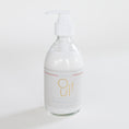Load image into Gallery viewer, Mersea Oui! Moisturizing Shea Cream in a clear glass bottle with a white pump dispenser and a white label featuring gold lettering, set against a clean white background.
