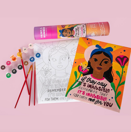 A Paint by Number craft kit depicting a woman wearing a headband against a background of flowers and sunshine, with the words "If they say its impossible, remember that its impossible for them, not for you." The crafting kit comes with a few paintbrushes and multiple paint colors 