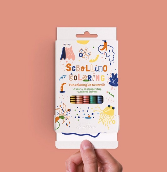 A hand holds the packaging for scrollino coloring book, filled with crayons and 1.5yds of paper to color on. 