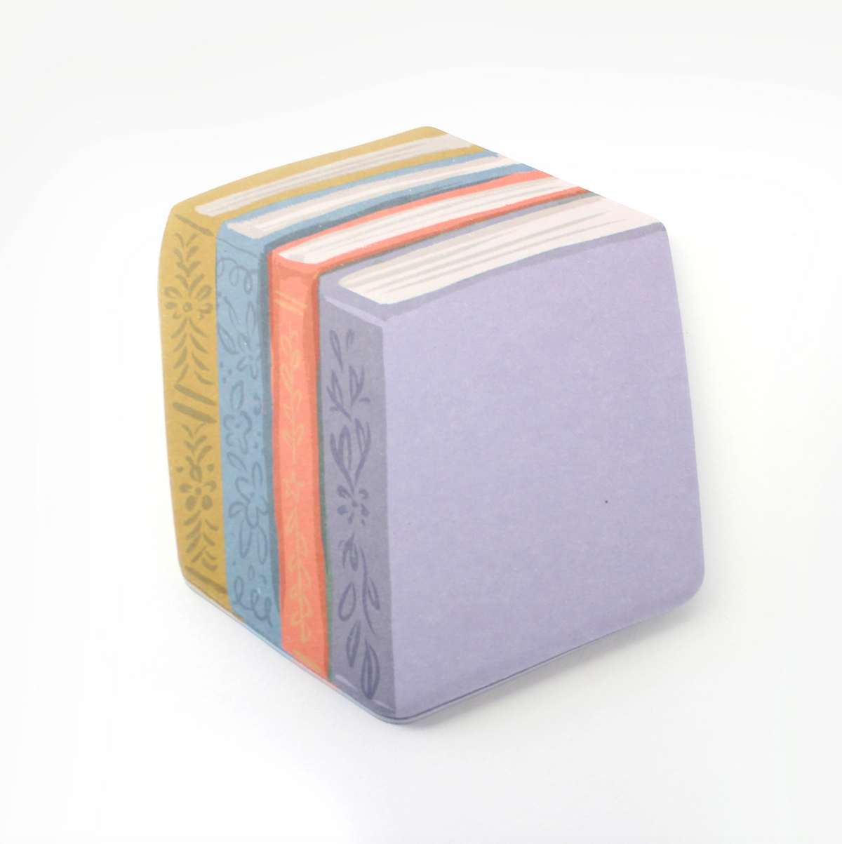 A stack of Book-Shaped Sticky Notes on a clean white background. The sides feature illustrated book spines in mustard yellow, light blue, coral orange, and white, with floral patterns.