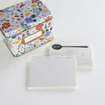 Load image into Gallery viewer, A floral recipe box with a gold label reading 'RECIPES' sits on a white surface next to recipe cards, one showing a black spoon-shaped divider.
