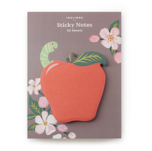 Apple-shaped sticky notes on a brown backing card that features florals and a green worm sticking out of the worm.