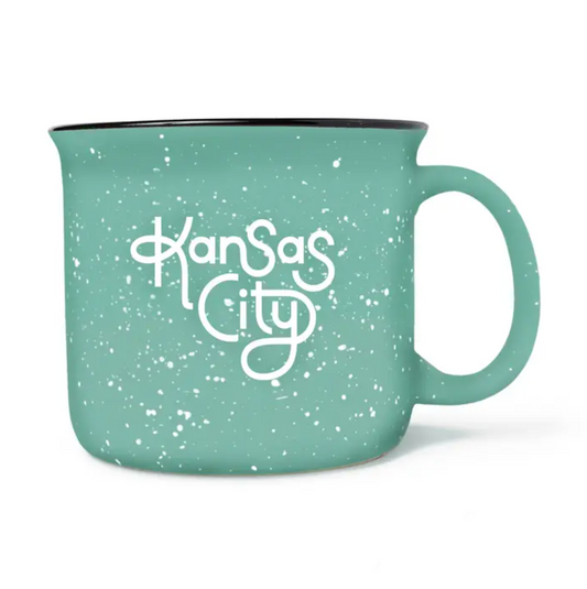 A mint green speckled enamel-style mug with a white 'Kansas City' script on the front, shown on a clean white background.
