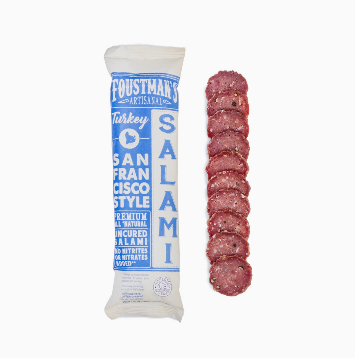A vacuum-sealed package of Foustman's Artisanal Turkey Salami stands next to a vertical row of sliced salami on a plain white background.
