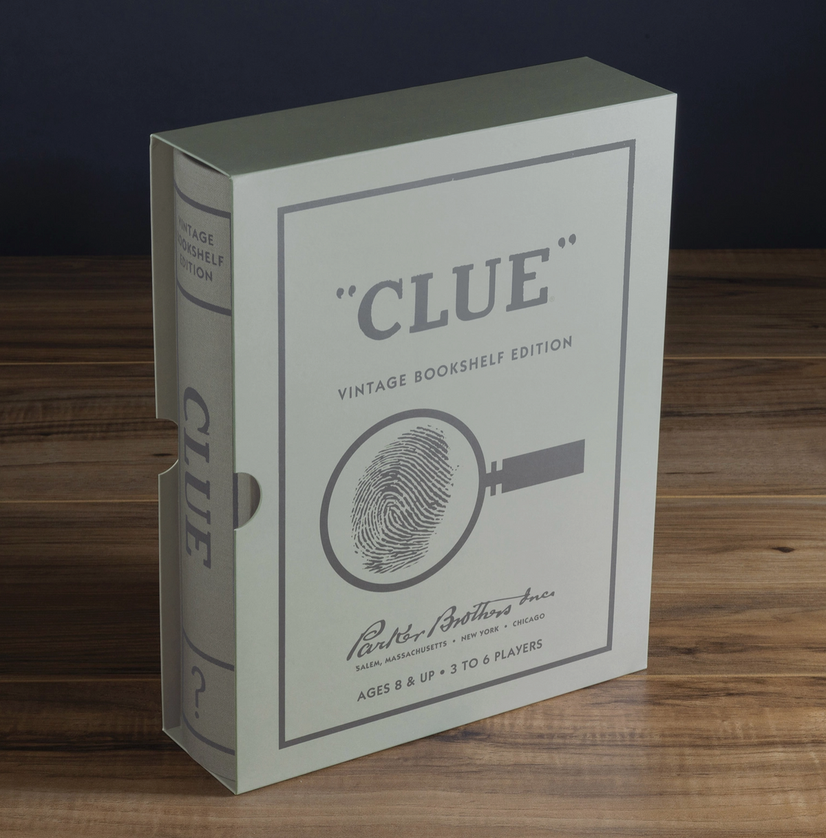 Vintage Bookshelf Edition Clue board game box, featuring a classic vintage design with a fingerprint magnifying glass illustration on the front, set on a wooden surface against a dark background.