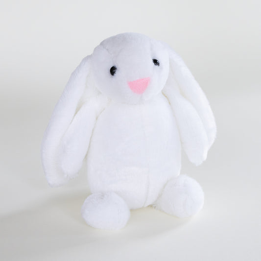 A white plush bunny toy with long floppy ears, small black eyes, and a pink stitched nose, sitting against a plain light background.